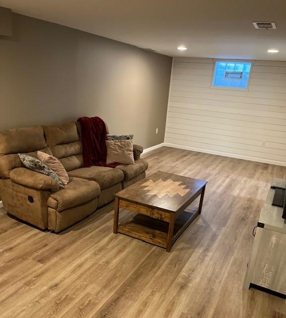 living area with visible vents, baseboards, and wood finished floors