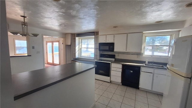 kitchen with light tile patterned floors, a sink, white cabinets, black appliances, and pendant lighting