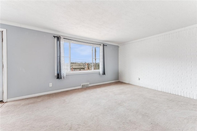 empty room featuring light carpet, visible vents, crown molding, and a textured ceiling