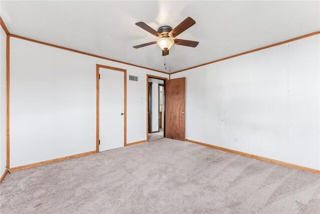 unfurnished room with ceiling fan, ornamental molding, visible vents, and light colored carpet