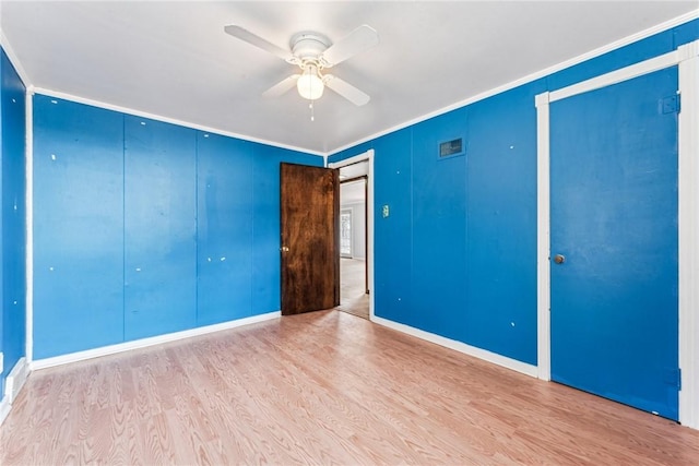 spare room with a ceiling fan, wood finished floors, and ornamental molding