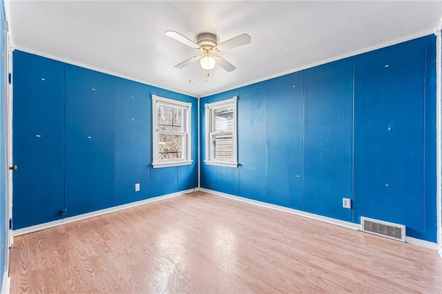 spare room with a ceiling fan, light wood-type flooring, and visible vents