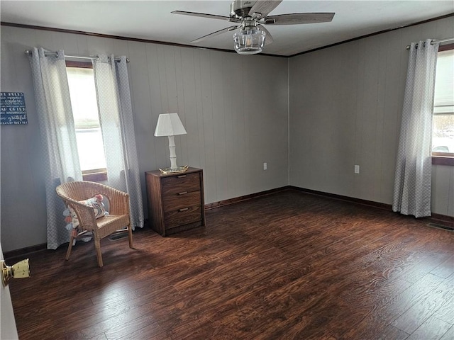 unfurnished room with visible vents, ornamental molding, a ceiling fan, wood finished floors, and baseboards