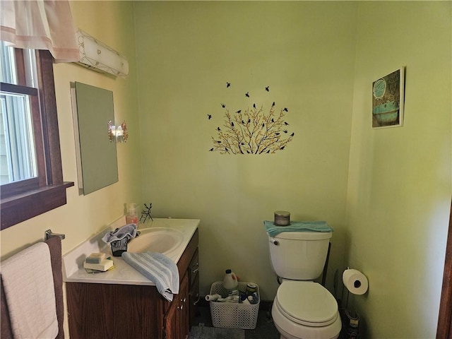 half bath featuring vanity and toilet