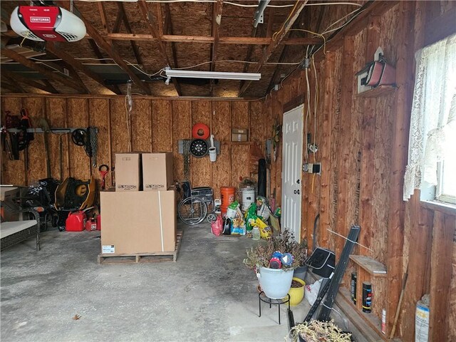 garage with wood walls and a garage door opener