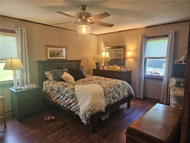 bedroom featuring a ceiling fan, ornamental molding, and dark wood-style flooring