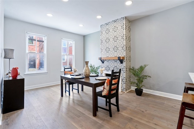 dining area with baseboards, wood finished floors, and recessed lighting