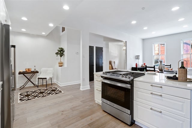 kitchen featuring stainless steel appliances, recessed lighting, light countertops, white cabinetry, and light wood-type flooring