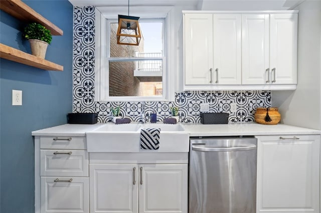 kitchen featuring dishwasher, a sink, and white cabinets