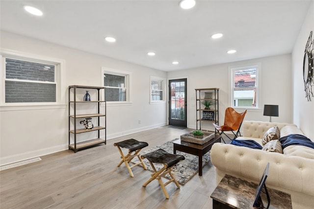 living area with recessed lighting, baseboards, and light wood finished floors