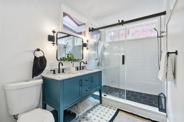 bathroom featuring a sink, a shower stall, toilet, and double vanity