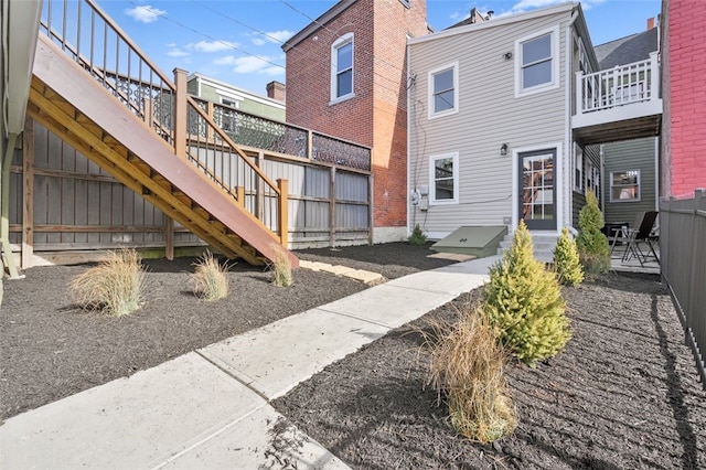 exterior space featuring entry steps, stairway, and fence