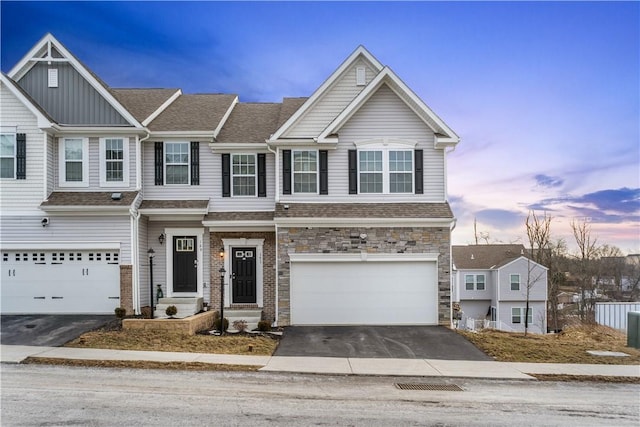 view of front of home with a garage, stone siding, roof with shingles, and driveway