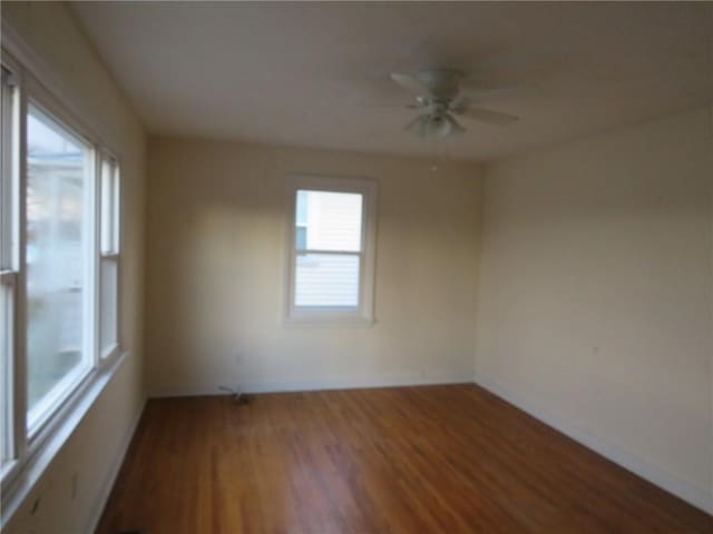 spare room featuring baseboards, a ceiling fan, and wood finished floors