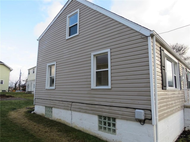 view of side of home with a yard