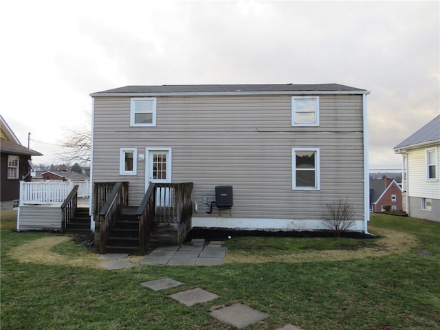 rear view of house featuring a yard and a wooden deck