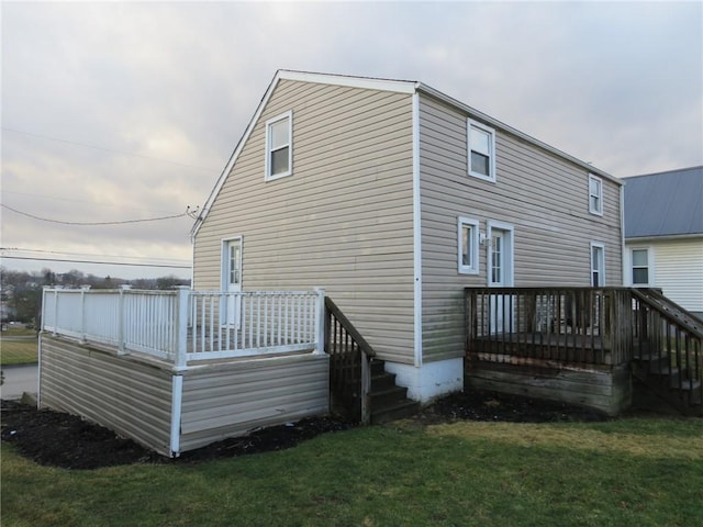 back of property with a lawn and a wooden deck