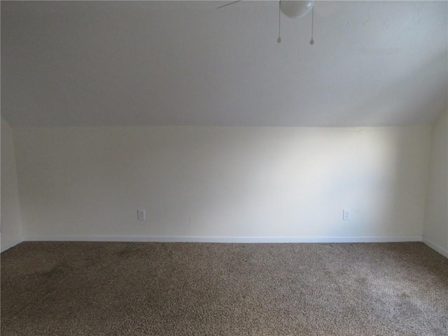 additional living space with carpet, baseboards, vaulted ceiling, and a ceiling fan