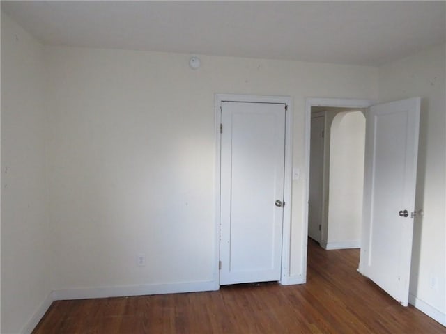 unfurnished bedroom with baseboards and wood finished floors