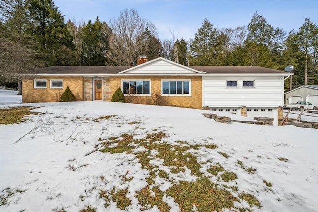 single story home with a garage, brick siding, and a chimney