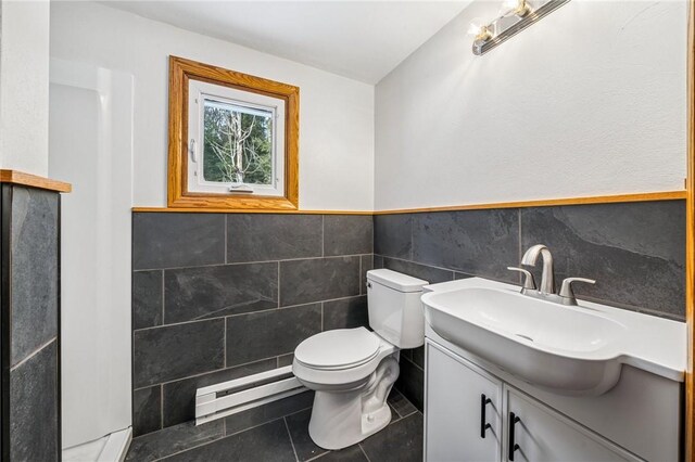 2972 Benshoff Hill Rd, Pa, PA 15909 - bathroom with tile walls, toilet, vanity, baseboard heating, and tile patterned flooring