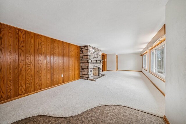 2972 Benshoff Hill Rd, Pa, PA 15909 - unfurnished living room with carpet floors, baseboards, a stone fireplace, and wood walls