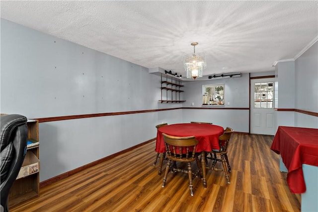 dining room featuring baseboards, dark wood finished floors, a textured ceiling, and a chandelier