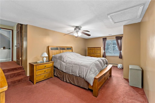 bedroom featuring attic access, a ceiling fan, dark colored carpet, a textured ceiling, and a baseboard heating unit