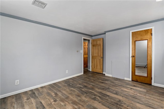 empty room with dark wood-style flooring, a baseboard radiator, visible vents, ornamental molding, and baseboards