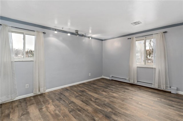 spare room featuring ornamental molding, visible vents, dark wood finished floors, and baseboard heating