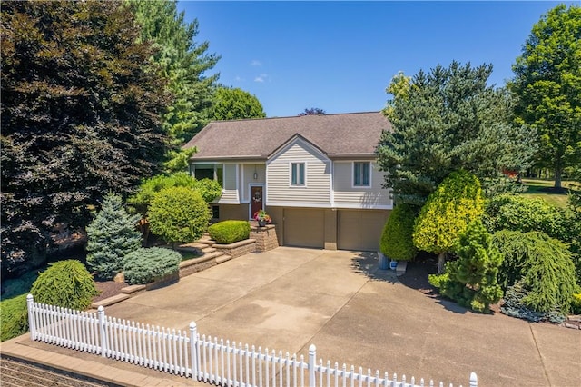 view of front of property featuring an attached garage, brick siding, a shingled roof, fence, and concrete driveway