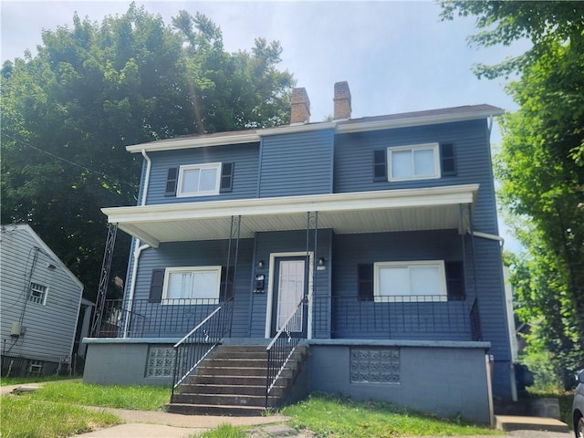 view of front of property featuring a porch and a chimney