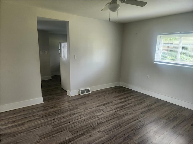 empty room featuring dark wood-style floors, baseboards, visible vents, and ceiling fan