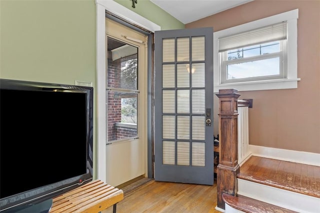 doorway to outside with baseboards and light wood-style floors