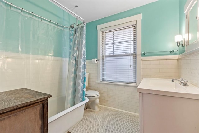 bathroom featuring a wainscoted wall, tile patterned flooring, shower / bath combination with curtain, vanity, and tile walls