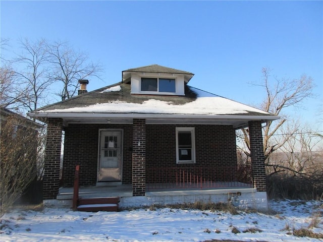 bungalow-style house featuring a porch and brick siding