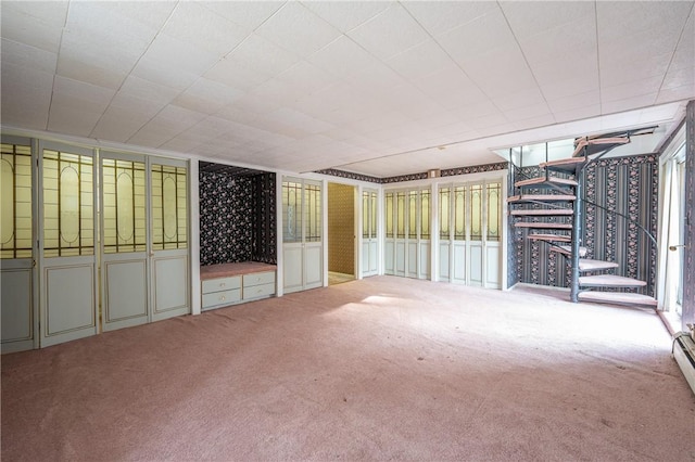 carpeted spare room featuring a baseboard heating unit