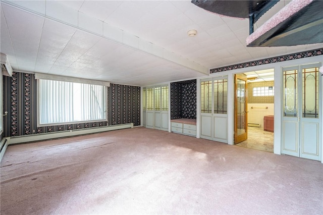 empty room with a baseboard heating unit, baseboard heating, and light colored carpet