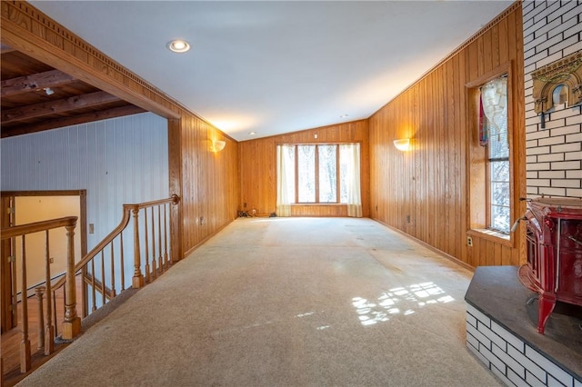 living room featuring lofted ceiling, light colored carpet, and wood walls