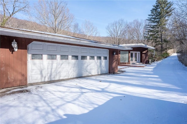 view of snowy exterior featuring a garage