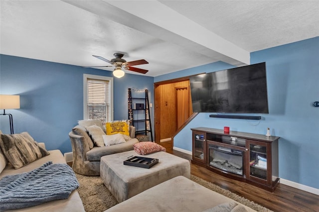 living area featuring baseboards, dark wood-style flooring, and a glass covered fireplace