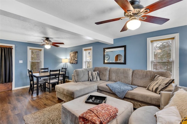 living area with plenty of natural light, baseboards, dark wood finished floors, and a textured ceiling