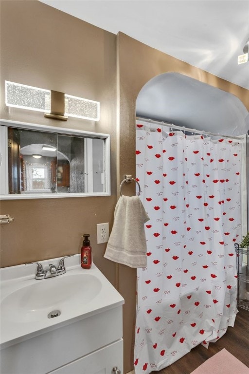 full bathroom with a shower with shower curtain, wood finished floors, and vanity