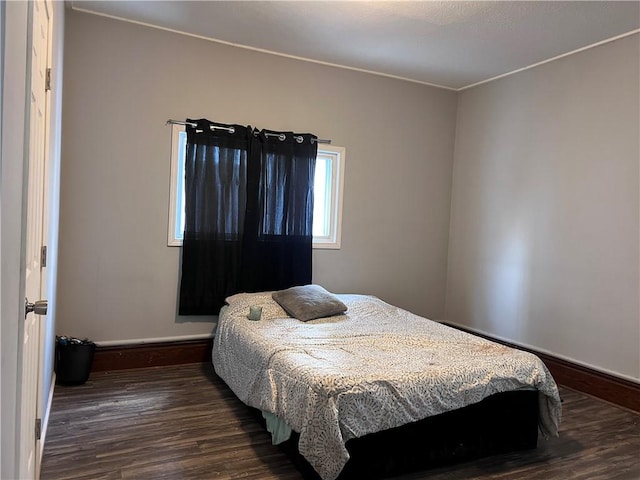 bedroom with baseboards and dark wood finished floors