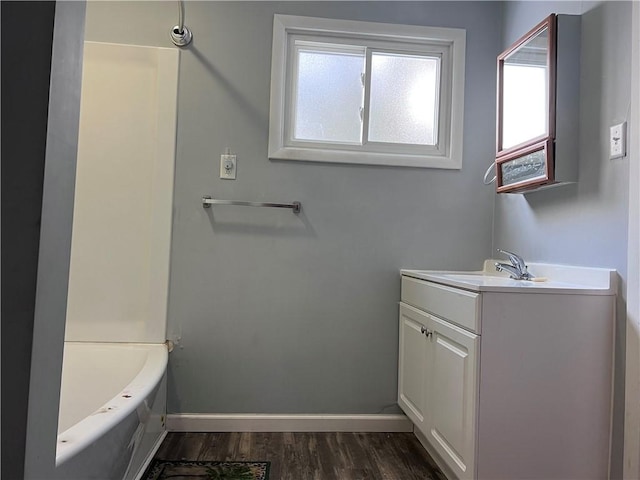 full bath with shower / washtub combination, wood finished floors, vanity, and baseboards