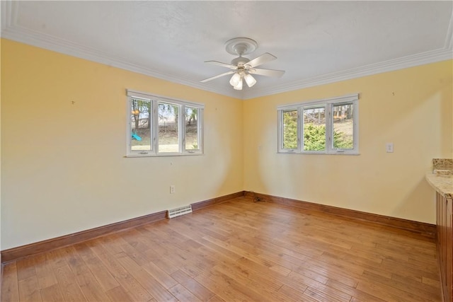 unfurnished room featuring light wood-type flooring, a wealth of natural light, and visible vents