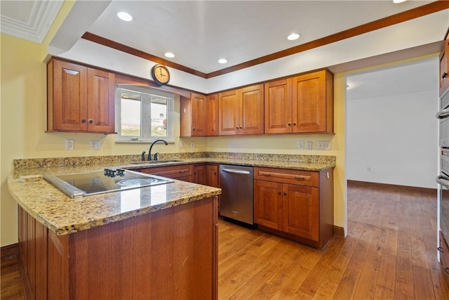 kitchen featuring black electric stovetop, light stone counters, a sink, light wood-style floors, and brown cabinetry