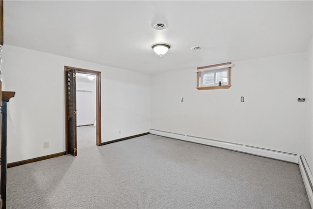 empty room with baseboards, a baseboard radiator, visible vents, and light colored carpet