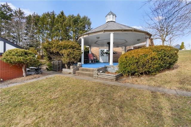 back of house with a gazebo and a lawn