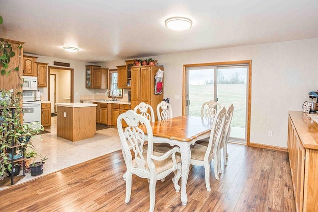 dining space with light wood-style floors and baseboards